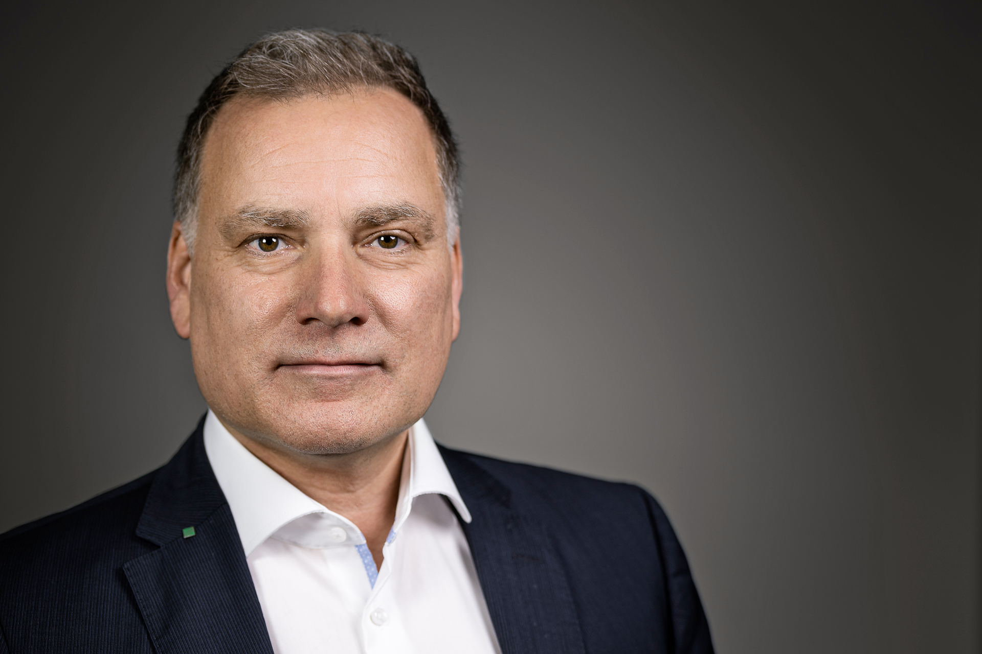 Porträt von Dietmar Laß. Er blickt leicht lächelnd in die Kamera.